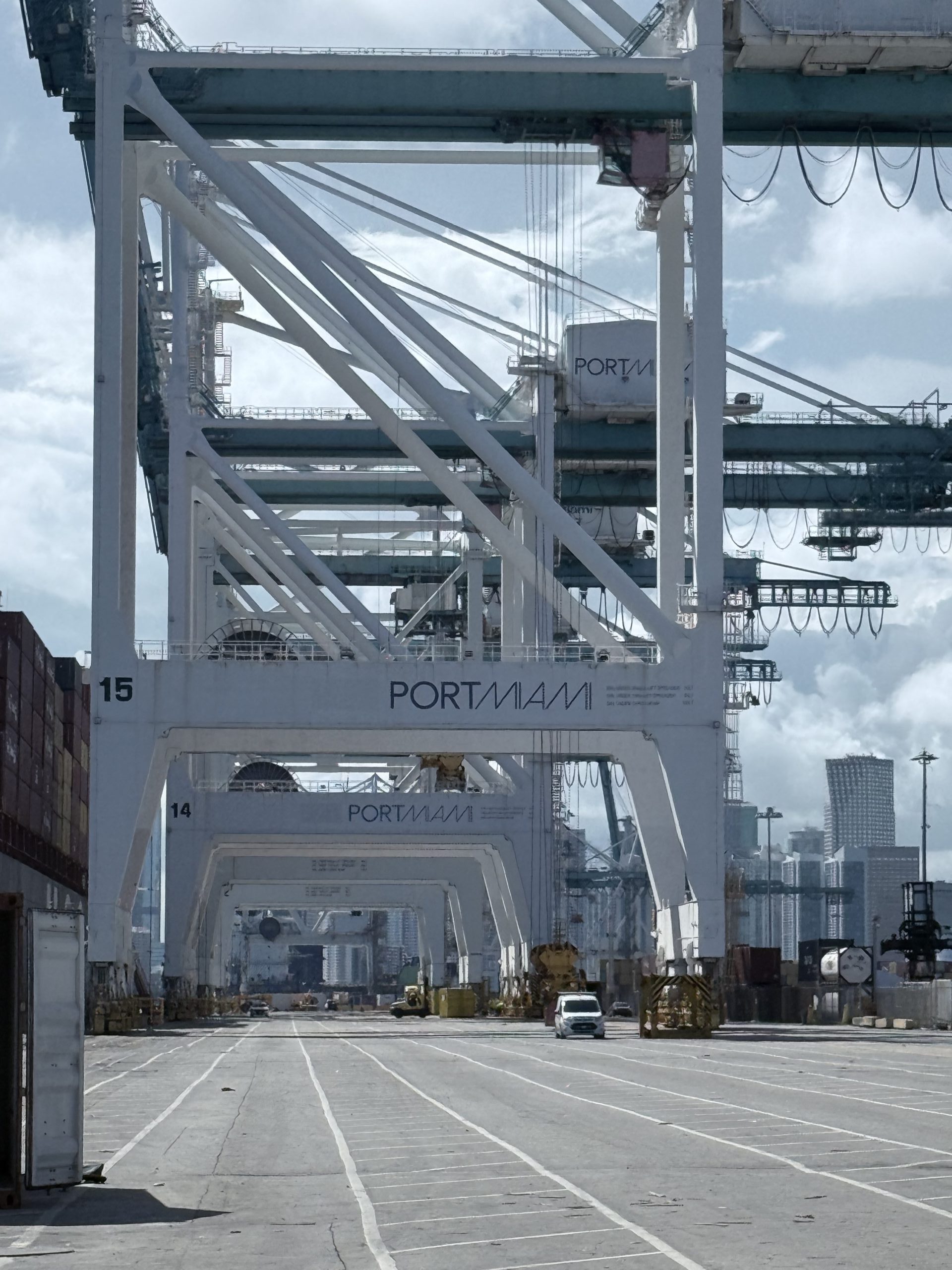 A detailed view of heavy-duty cranes and port machinery in operation, essential for unloading and loading shipping containers at PortMiami.