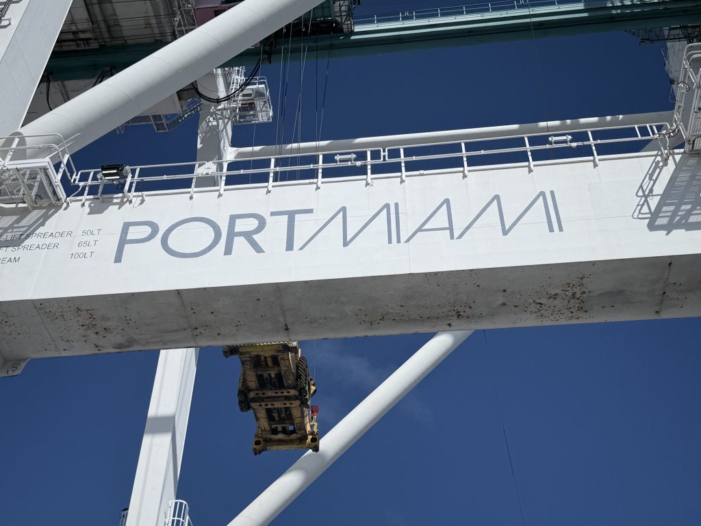 A photo of the “PORTMIAMI” signage on cargo-handling equipment, symbolizing the gateway role Miami plays in Caribbean and Latin American trade.